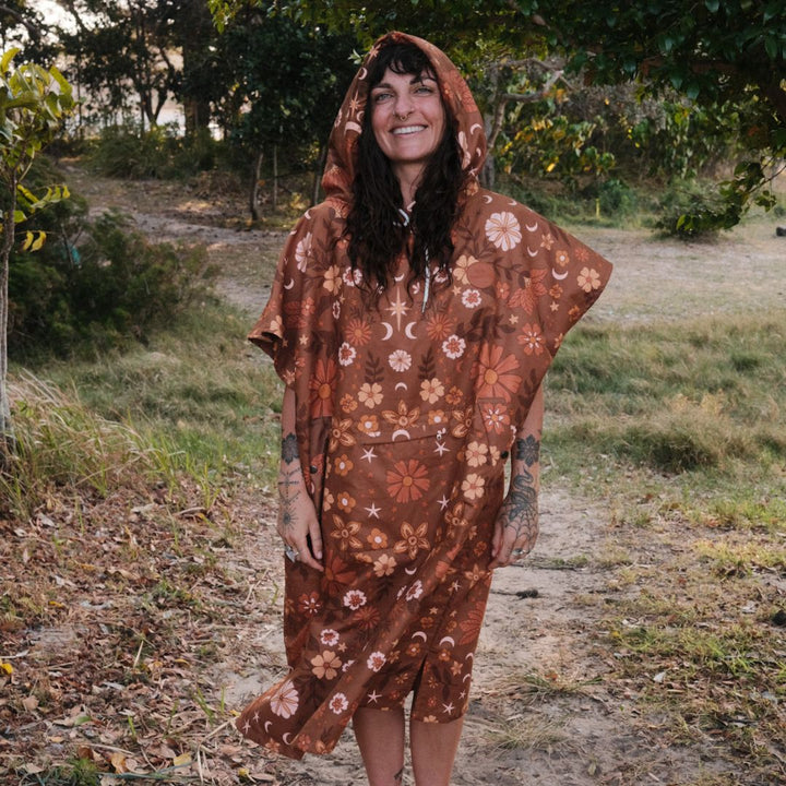 Woman wearing a brown floral patterned poncho in a natural setting