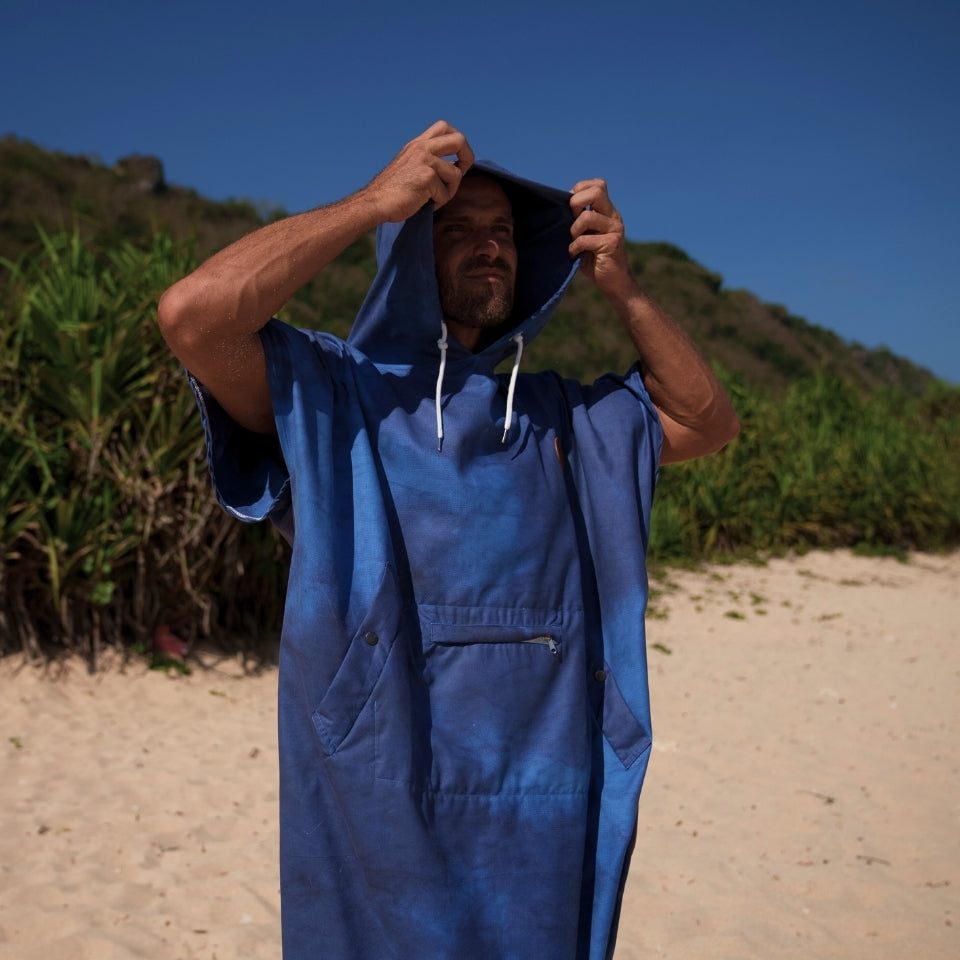 Adult male ocean poncho surf change