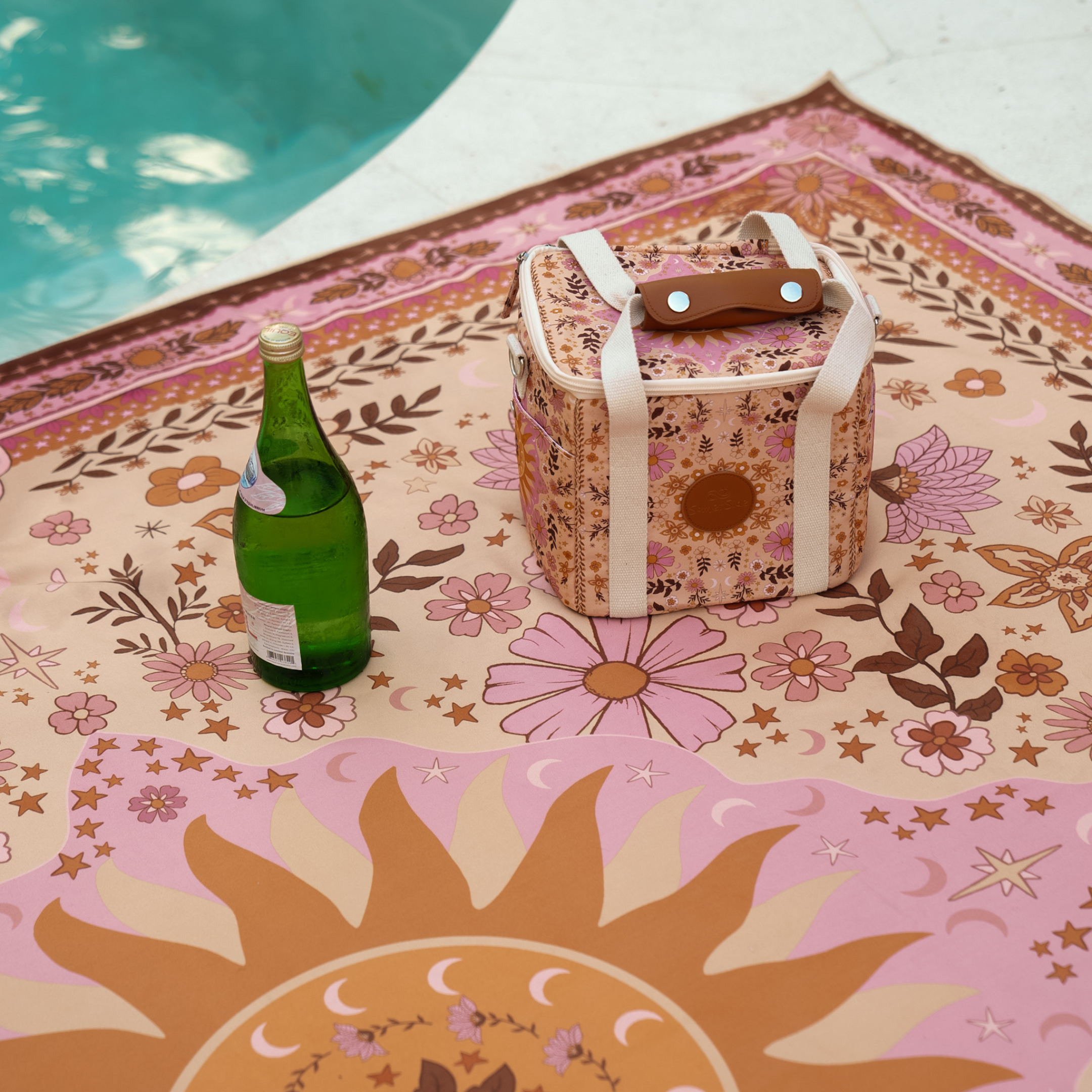 Floral-patterned  boho cooler with a bottle by a poolside