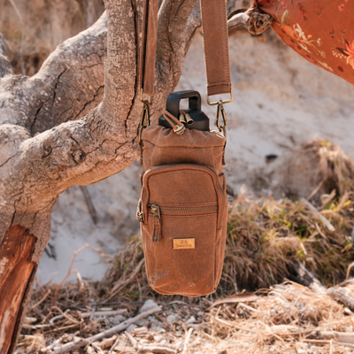 water bottle insulated bag hanging from branch at the beach