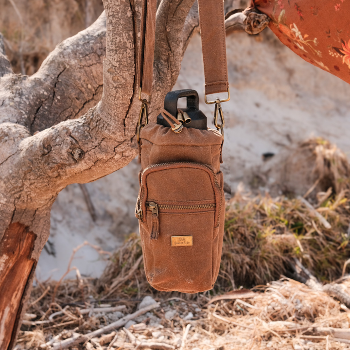 water bottle insulated bag hanging from branch at the beach