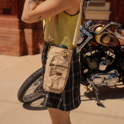 Person holding a beige bottle bag 