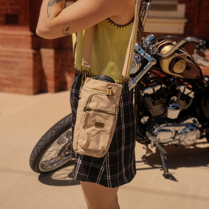 Person holding a beige bottle bag 
