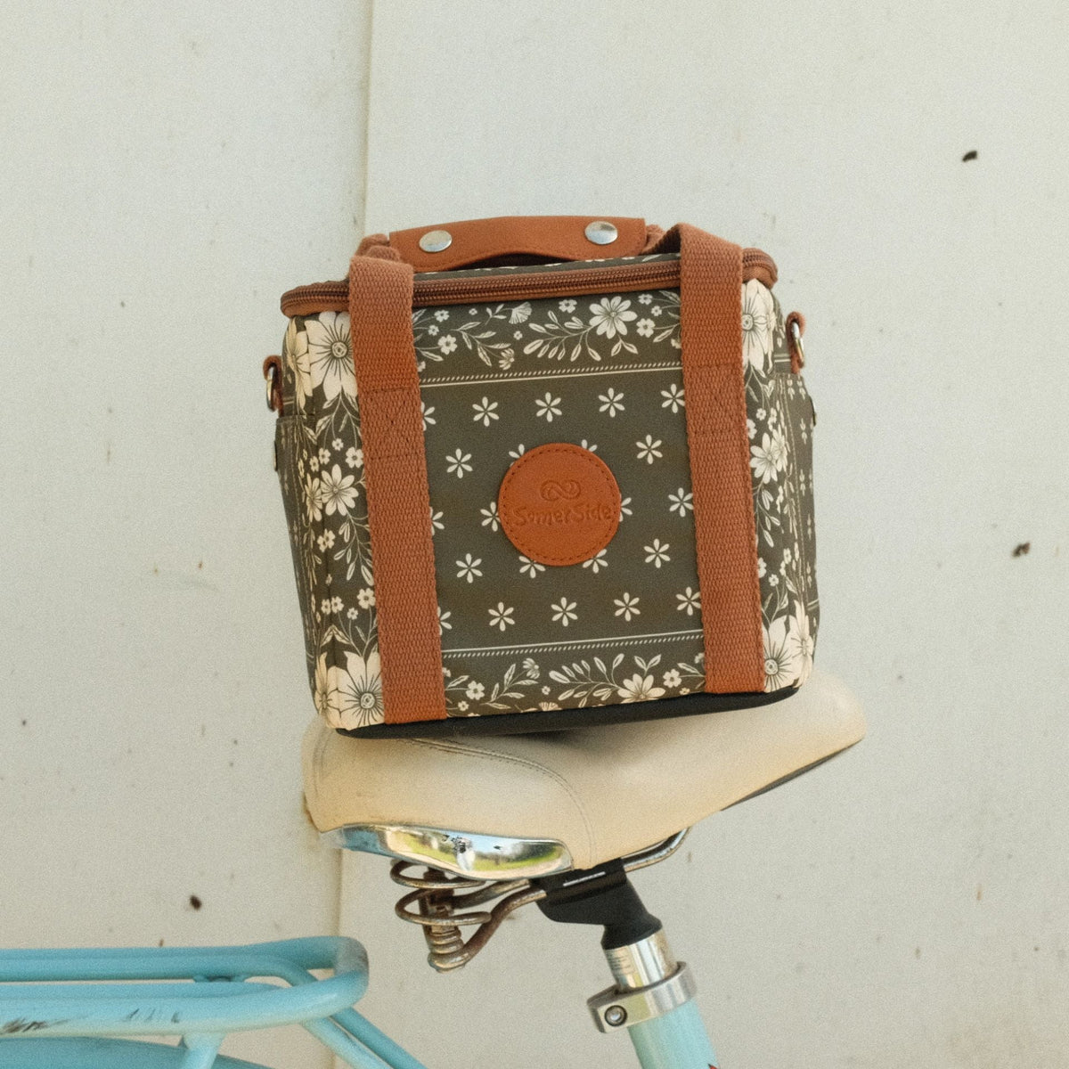 Eden mini insulated cooler bag, olive green floral bandana print, on a bike seat