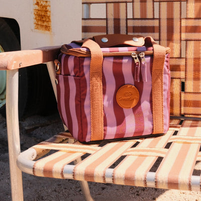 Jagger Shiraz mini insulated cooler bag, burgundy and mauve wavy stripe, on a camp chair, side view