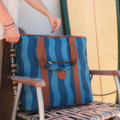 Jagger Tidal beach tote bag, two-tone blue wavy stripe, on a camp chair with zip pocket