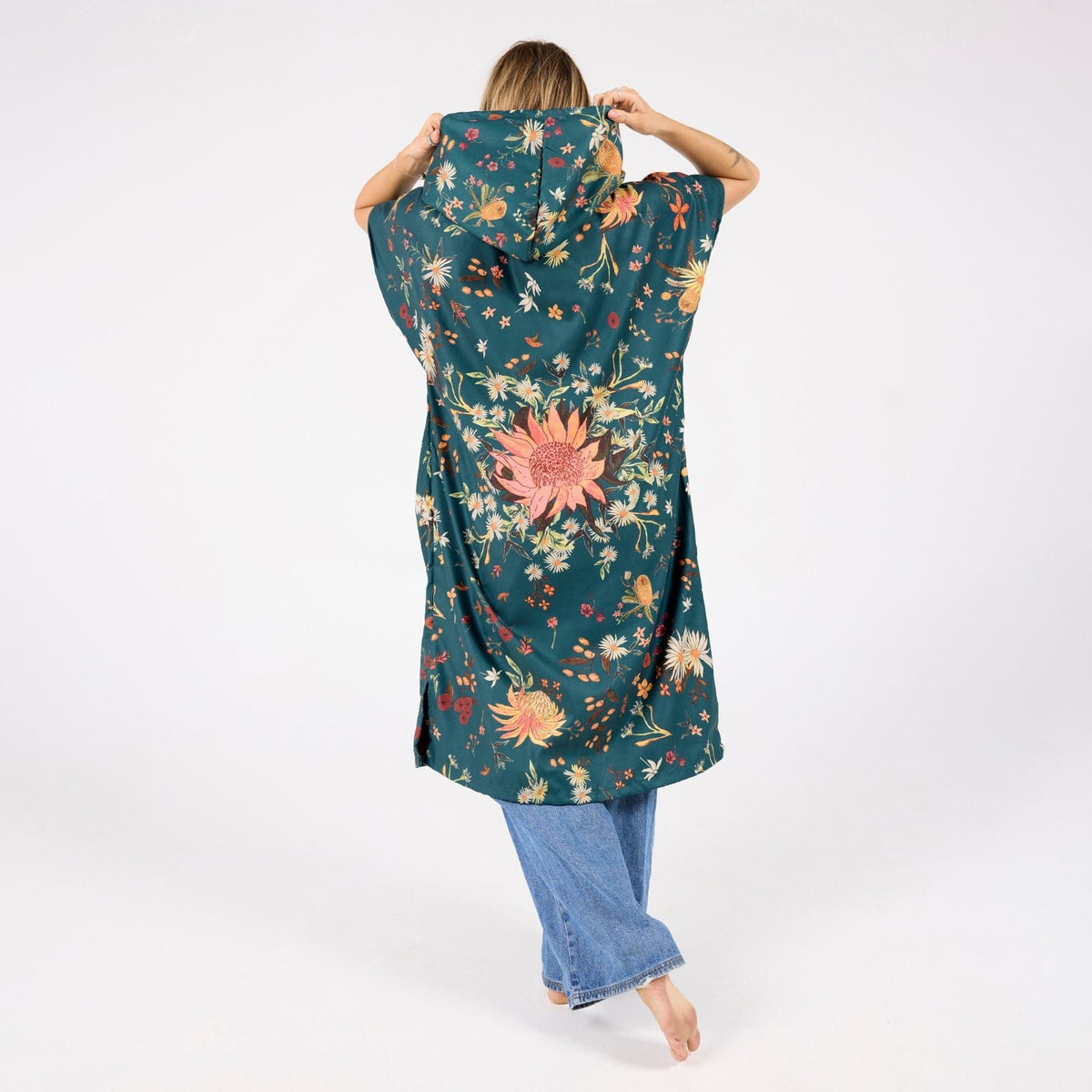 Native Botanical adult hooded towel poncho, dark green Australian wildflower print, back view on model
