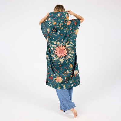 Native Botanical adult hooded towel poncho, dark green Australian wildflower print, back view on model