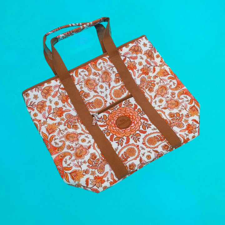 Floral-patterned bag with brown straps floating in pool