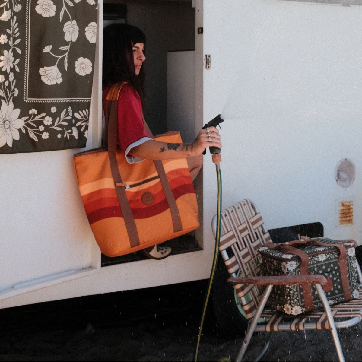 Stevie beach tote bag, orange retro 70s wave print, on the shoulder at a caravan