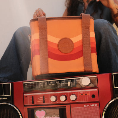 Stevie mini insulated cooler bag, orange retro 70s wave print, on a retro boombox, close up