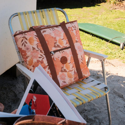 Summer Muse beach tote bag, peach retro 70s floral print, on a retro camp chair