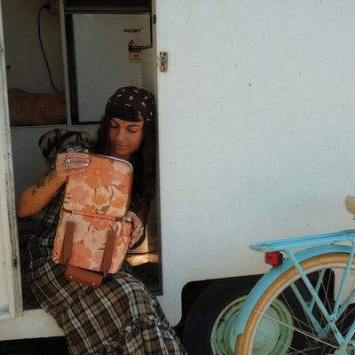 Summer Muse mini insulated cooler bag, peach retro 70s floral print, opened in a caravan doorway