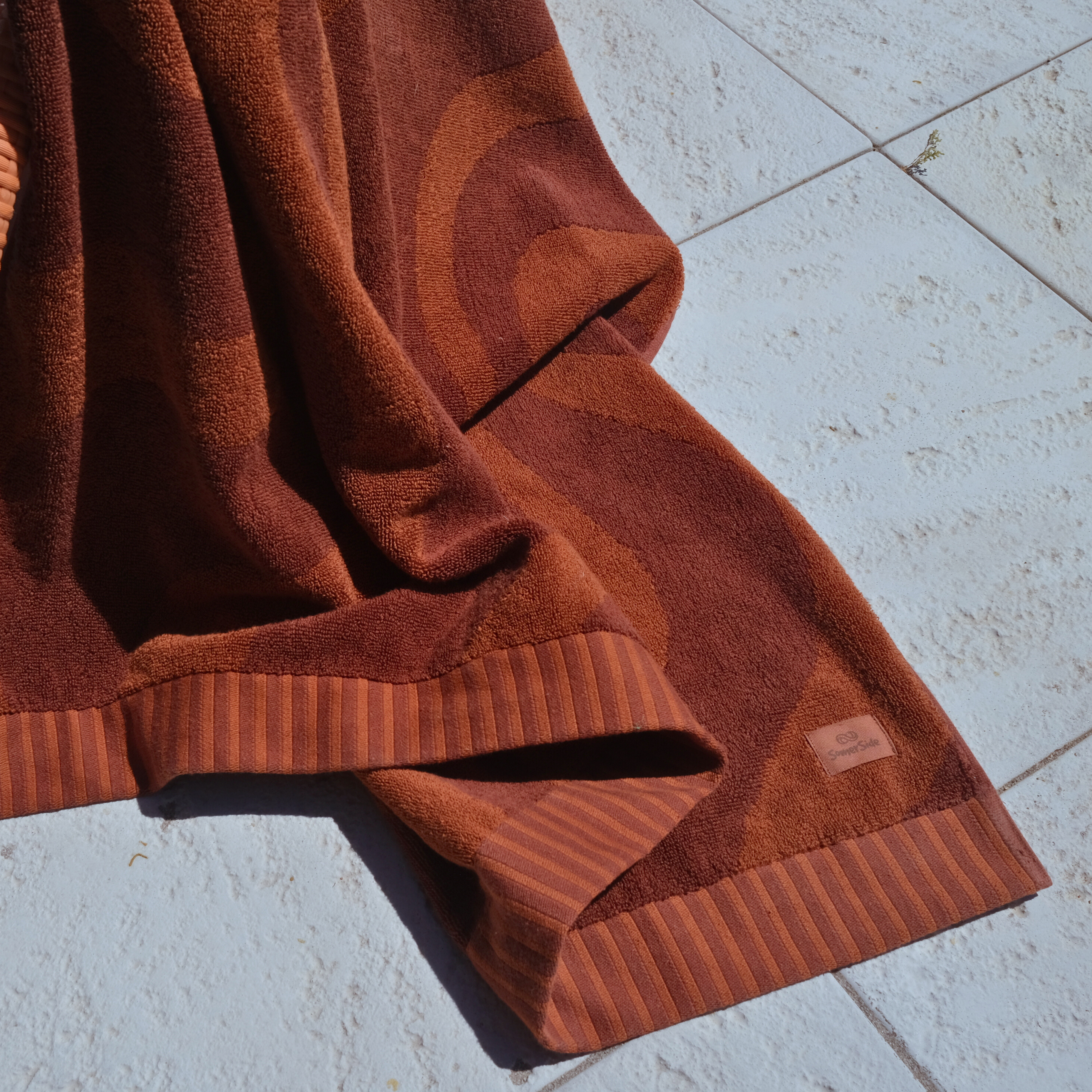 Brown fleece blanket on a light stone floor